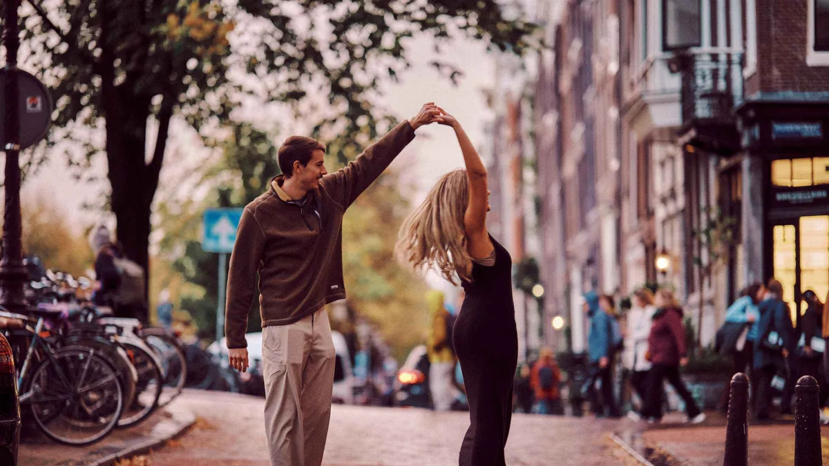 Photographer directing a couple on a Jordaan canal bridge during an Amsterdam photoshoot, Amsterdam