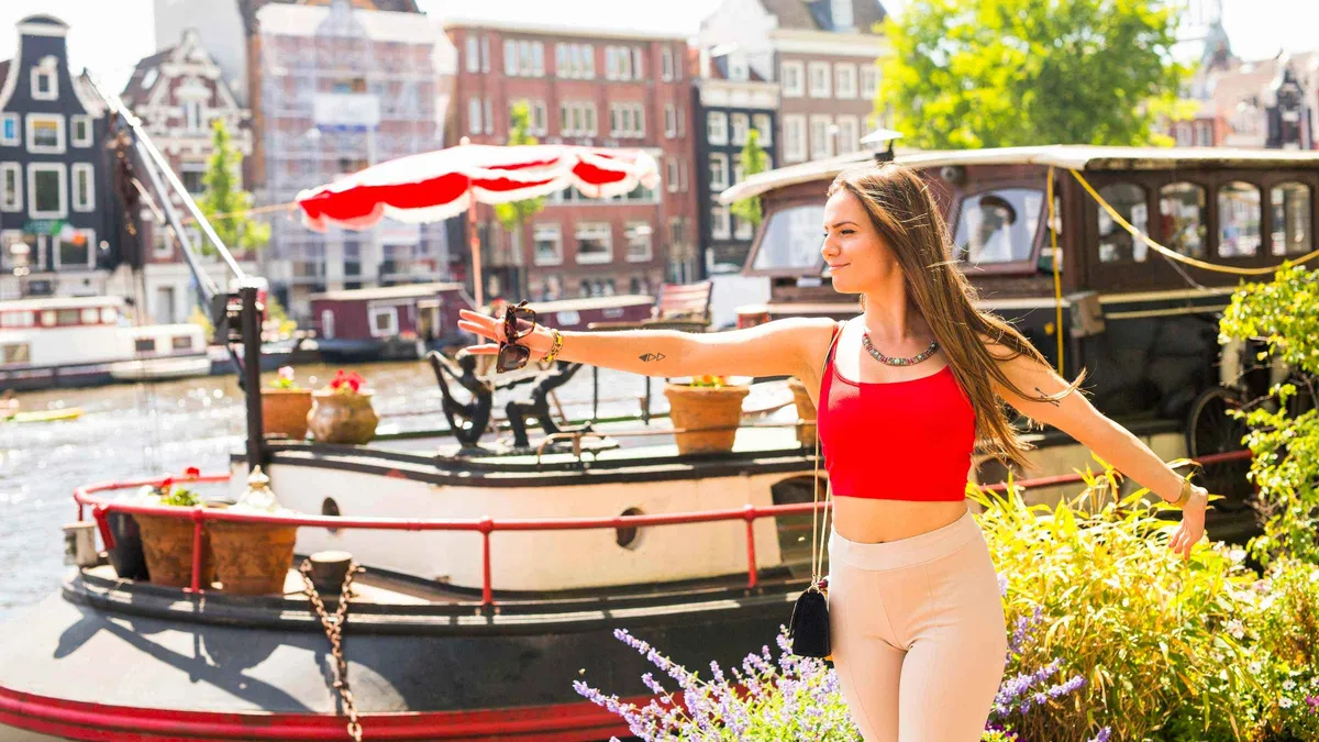 Guide photographing a visitor beside a canal bridge on an Amsterdam photo spots tour, Amsterdam