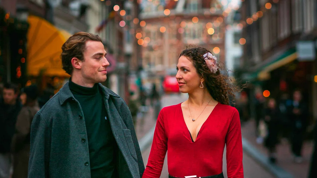 Couple embracing on a Negen Straatjes bridge during a romantic Amsterdam photoshoot, Amsterdam
